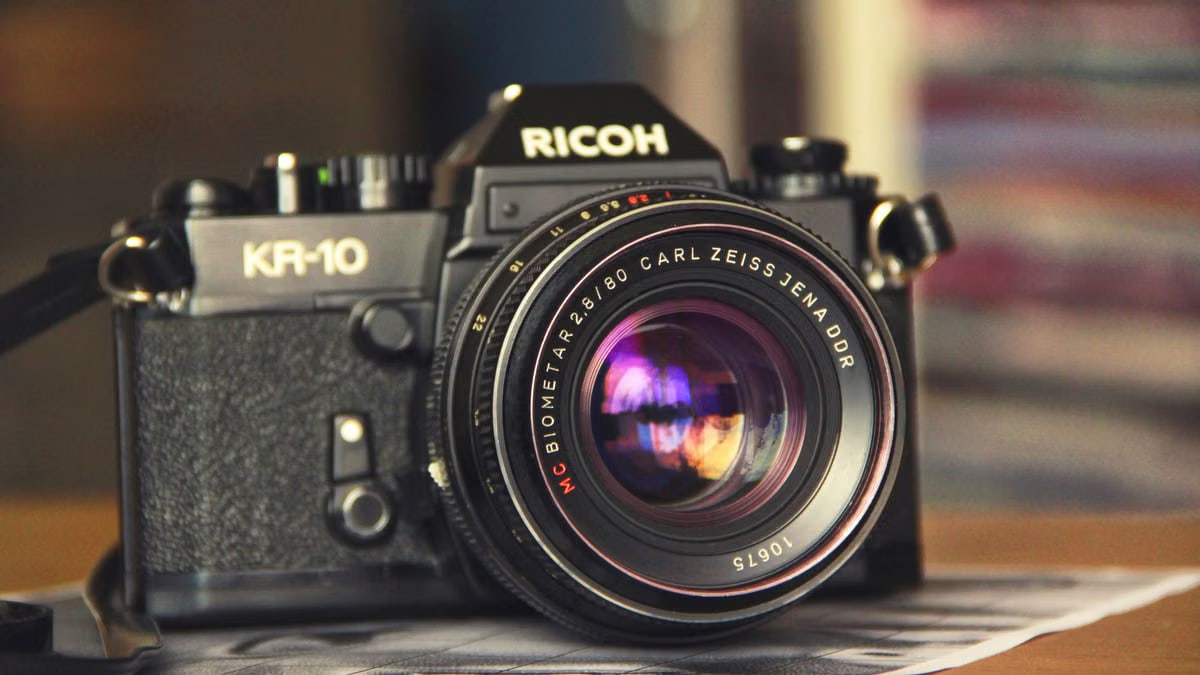 Close-up of a classic Ricoh KR-10 camera with a Carl Zeiss Jena lens, showcasing vintage photography equipment.